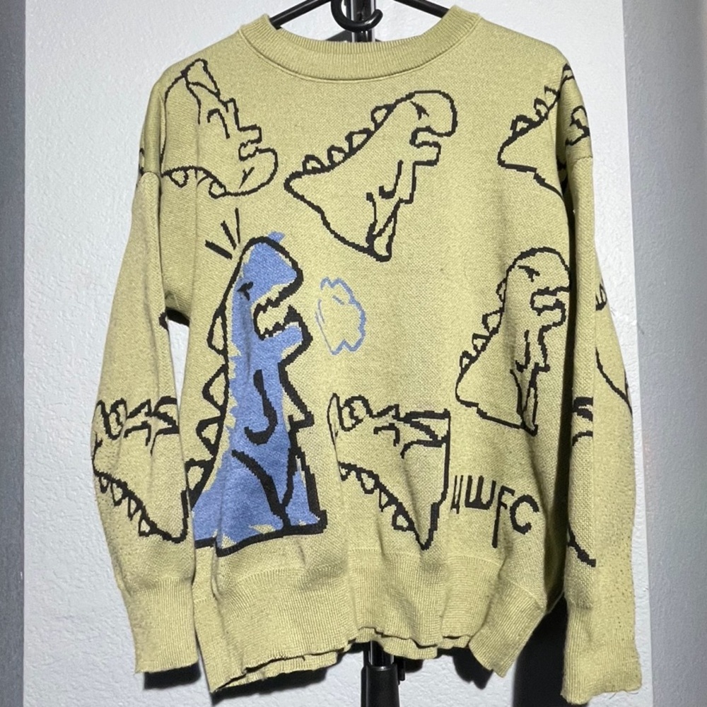 a green dinosaur sweater